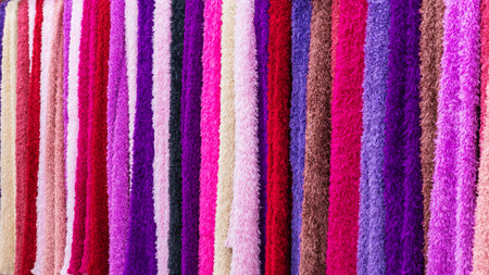Variety of beautiful colorful cloth made from bamboo pulp for good health hanging for sale in shopping mall or department store in Vietnam. Colorful cloth hang on display. Bright multicolored fabrics.の写真素材