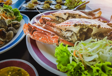 Top view of variety Seafood party table with scallop, cockle, crab, clams, shrimps, crayfish on black background. Seafood platter on black wooden table. Assortment of different seafood with vegetablesの写真素材