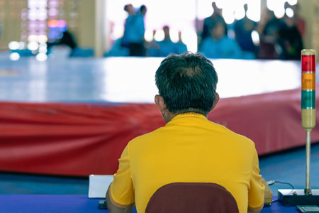 Back view of Judges work during Wushu Boxing Cup among young women, juniors and girls. The referee scores points at table in the women boxing match. New Fighting Generation, Mixed Martial Arts.の写真素材