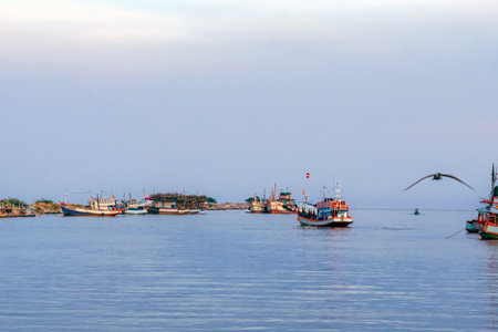 PHETCHABURI-THAILAND,OCTOBER 23, 2022 : Beautiful scenic of variety colorful fishing boats at pier with seaview in evening at Phoo Chuk Bridge,Cha-Am. Commercial fishing vessels docked at fish villageのeditorial素材