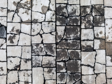 Top view texture of the brick blocks floor in the cracks. The surface of the public outdoor walkway or pavement is broken and damaged. Cracked brick, Close up Damaged cement pathway floor background.の写真素材