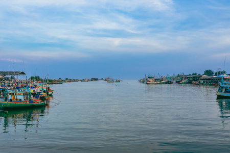 PHETCHABURI-THAILAND,OCTOBER 23, 2022 : Beautiful scenic of variety colorful fishing boats at pier with seaview in evening at Phoo Chuk Bridge,Cha-Am. Commercial fishing vessels docked at fish villageのeditorial素材