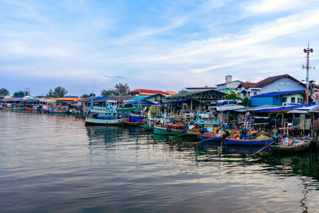 PHETCHABURI-THAILAND,OCTOBER 23, 2022 : Beautiful scenic of variety colorful fishing boats at pier with seaview in evening at Phoo Chuk Bridge,Cha-Am. Commercial fishing vessels docked at fish villageのeditorial素材