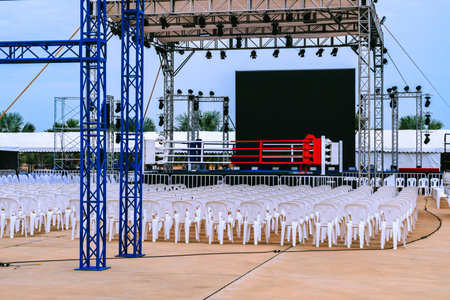 Boxing ring and many chairs for spectators prepared for competition, Outdoors. Sport and empty...