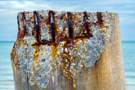 Beautiful view of leaning pillars of the old pier. Slanted concrete pole beach. Abandoned fishing...