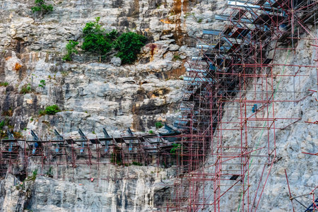 Beautiful view of build structure skywalk bridge on cliff mountain in construction site and garden park of new tourist attraction in Suphan Buri,Thailand.Construction of glass walkway along high cliffの写真素材