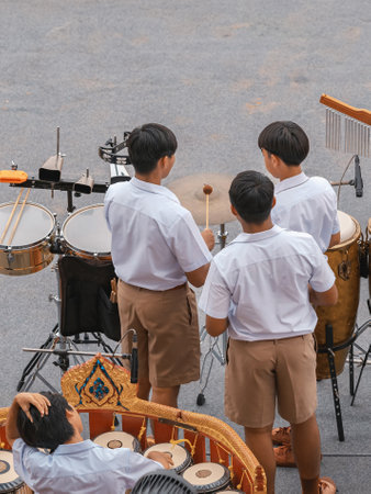 Group of Asian students in uniform perform a orchestra band in festival performance at stadium. Students play marching band in celebrations. Students Music band playing Jazz Music. Education outdoors.の写真素材