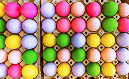 Multicolored easter eggs in egg tray. Creative Easter concept. Colorful handmade Easter eggs in paper container. Multicolored eggs in a cardboard egg carton. Egg in recycled basket protein breakfast.の写真素材