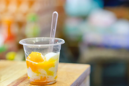 Hard boiled eggs in plastic cup ready to eat from the shop grilled eggs street food of Thailand. Breakfast with soft boiled egg in plastic cup served on wooden table. Traditional homemade simple food.の写真素材