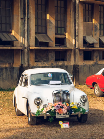KANCHANABURI,THAILAND-FEBRUARY 12,2024 : An exhibition of beautiful antique cars decorated with artificial flower bouquets on lawn at The old paper mill. Vintage car with beautiful flower bouquet.のeditorial素材
