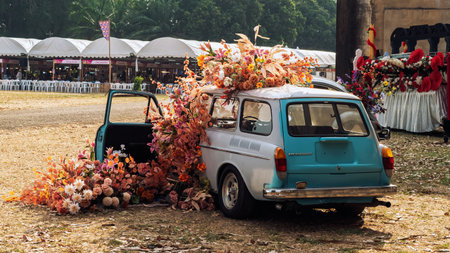 KANCHANABURI,THAILAND-FEBRUARY 12,2024 : An exhibition of beautiful antique cars decorated with artificial flower bouquets on lawn at The old paper mill. Vintage car with beautiful flower bouquet.のeditorial素材