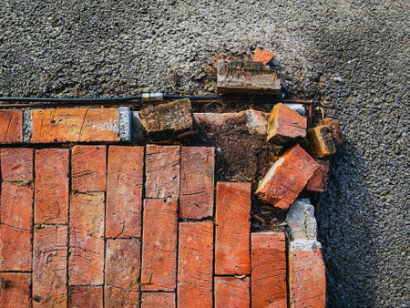 Close up to Crack concrete corner stair, Top view of broken border brick floor,  Bricks floor causes deterioration or cracking. Brick layer around the edges loose and broken. Abstract surface detail.の写真素材