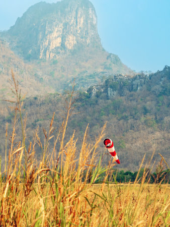 Windsock indicator of wind in meadow with beautiful scenic. Flying windsock or wind vane in field. meteorology. Airport windsock. Air field direction sign , Air sock, Drogue, Wind sleeve, Wind cone.の写真素材