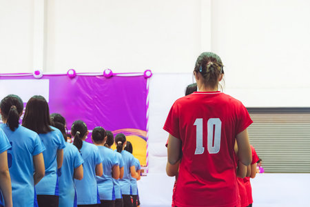 Female volleyball players line up to receive their medals during competition. Athletes women line up for the medal ceremony. Group of students in uniforms standing in line during a school sports day.の写真素材