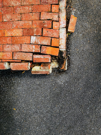 Close up to Crack concrete corner stair, Top view of broken border brick floor,  Bricks floor causes deterioration or cracking. Brick layer around the edges loose and broken. Abstract surface detail.の写真素材