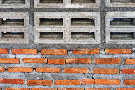 Old dirty cement ventilation block and red brick wall. Abstract hollow concrete cement brick block...