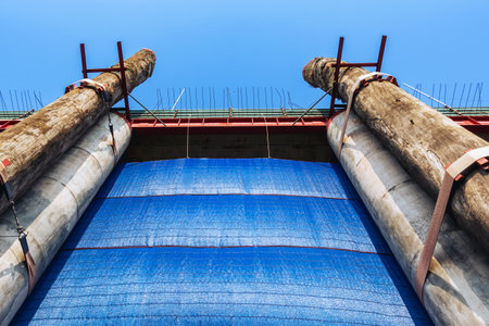 Large wooden posts attached to concrete posts to support the strength of construction. Appearance of...