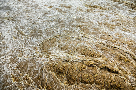 Smudged water flows profusely. River water flowing profusely. Flood waters rushing down river after...