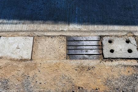Gutter cover grate type and concrete drain caps made of cement, Cover of water drain on road to collect rainwater for sewage system. Rainwater sewer cover. Concrete and sheet metal manhole covers.の写真素材