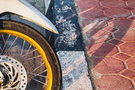 Front wheel of motorcycle fell down by the road is bent and deformed. Damaged motorcycle wheel with...