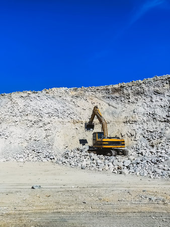 Huge heavy excavation digger with shovel at limestone stone quarry. Large construction excavator on construction site in quarry for quarrying sand and stone. Extraction of stone in quarry. Backhoe.の写真素材