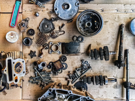 Old parts of motorcycles background. Repair and maintenance old parts of engine. Old motorcycle spare parts on corrugated paper background. Disassembly of spare parts, gear, differential, engine, old.の写真素材