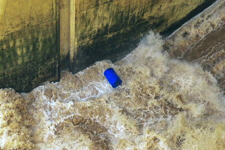 Water flows profusely. River water flowing profusely. Flood waters rushing down river after storm flows through. Turbulent river dam. Water turbulence of river due to dam. Water Nature Textureの写真素材