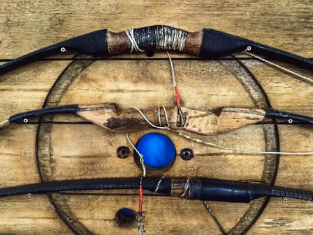 Collection of old classic handicraft wooden bows handle hang on wall as decorations. Wooden bow...