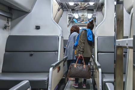 Female passenger travels by train and stores luggage in luggage compartment of sleeper train. Woman...