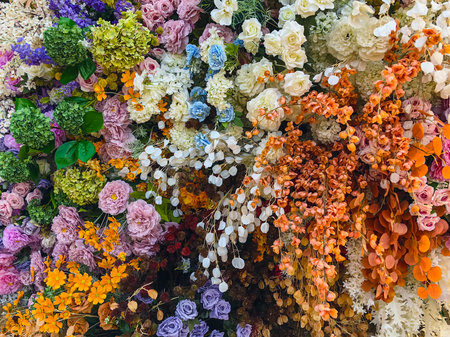 Decorated and embellished with beautiful vibrant artificial flower bouquets arrangements. Colorful artificial flowers as background or backdrop. Multicolored floral pattern wallpaper. Adorned flowersの写真素材