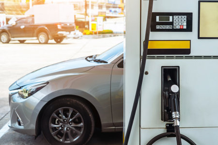 Petrol fuel nozzle for fuelling in petrol fuel station. Hand refilling car with fuel at refuel...