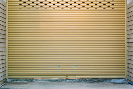 Aluminium steel metal roller shutter door in warehouse building industry. Yellow shutter door with...