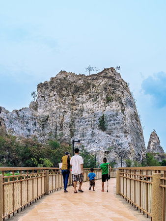Back view of lovely family enjoy walking on the walkway with beautiful nature scenic landscape with stone mountain range also call Snake Mountain at Khao Ngu Stone Park in Thailand. Amazing nature.の写真素材