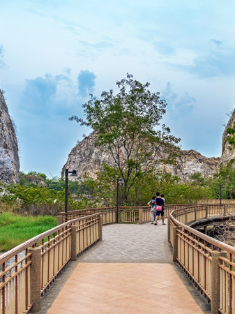 Back view of lovely father and daughter enjoy walking on the walkway with beautiful nature scenic landscape with stone mountain range also call Snake Mountain at Khao Ngu Stone Park. Amazing nature.の写真素材