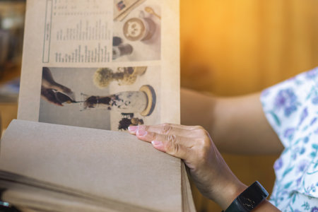 Close up to woman finger with menu choosing dishes at restaurant. A person reading menu at table. Woman with menu in restaurant making order. People select order from menu. Order food through menu.の写真素材