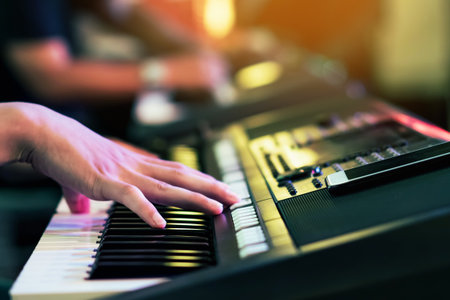 Hands of male musician press digital electronic keyboard synthesizers on concert stage. Pianist man...