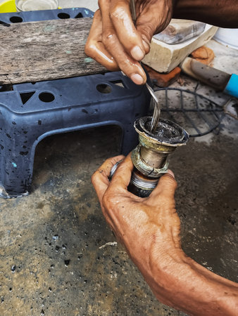 Clogged sink pipe in hands ,A plumber cleans a clogged siphon pipe of a sink in the kitchen. Clogged rusty water trap siphon and drainage pipe cleaning. Home plumbing maintenance service. DIY conceptの写真素材