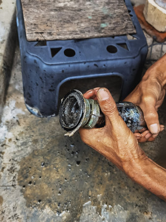 Clogged sink pipe in hands ,A plumber cleans a clogged siphon pipe of a sink in the kitchen. Clogged rusty water trap siphon and drainage pipe cleaning. Home plumbing maintenance service. DIY conceptの写真素材