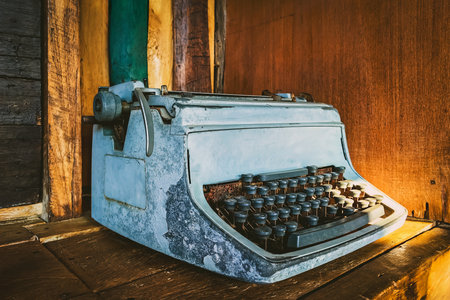 Old rusty broken business Thai typewriter collection. Ancient vintage typewriter with damaged weathered keys. Rusty dirty old decaying vintage antique typewriter. Essential antique office equipmentの写真素材
