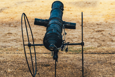 Replica of ancient cannon made of black painted steel on field can emits smoke and makes a sound like a real bullet being fired using an electronic system to accompany the outdoor retro performance.の写真素材
