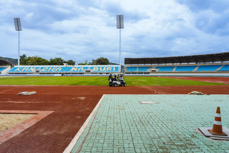 KANCHANABURI, THAILAND-AUGUST 8, 2025 : Unidentified team of landscape workers installing fresh natural sod rolls on prepared soil ground for professional sports field project at Kleeb Bua Stadium.のeditorial素材