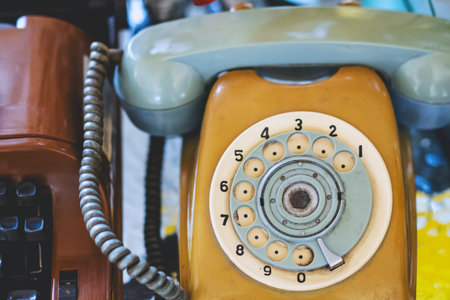 Vintage rotary dial telephone wheel. Circular rotary dial wheel with numbers from 1 to 0 of an antique beige telephone. Nostalgic details and retro textures of analog communication