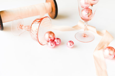 A pink spool of thread lies on a white background and pink objects aroundの写真素材