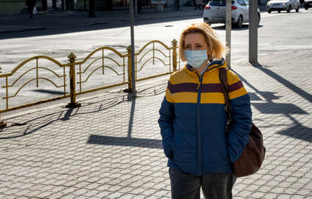 Lutsk, Ukraine - April 20,2020: A woman wearing face mask on a public streets in the middle of coronavirus epidemic. Health protection, virus outbreak prevention during infectious diseases in the cityのeditorial素材