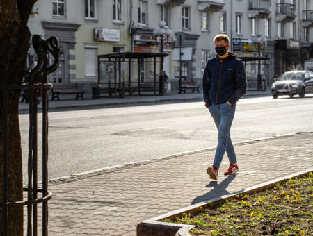 Lutsk, Ukraine - April 20,2020: A man wearing face mask on a public streets in the middle of coronavirus epidemic. Health protection, virus outbreak prevention during infectious diseases in the cityのeditorial素材