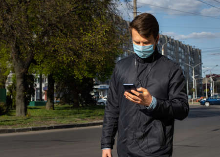 Lutsk, Ukraine - May 20,2020: A man wearing face mask on a public streets in the middle of coronavirus epidemic. Health protection, virus outbreak prevention during infectious diseases in the cityのeditorial素材