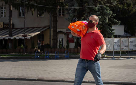 Lutsk, Ukraine - May 20,2020: A man wearing face mask on a public streets in the middle of coronavirus epidemic. Health protection, virus outbreak prevention during infectious diseases in the cityのeditorial素材