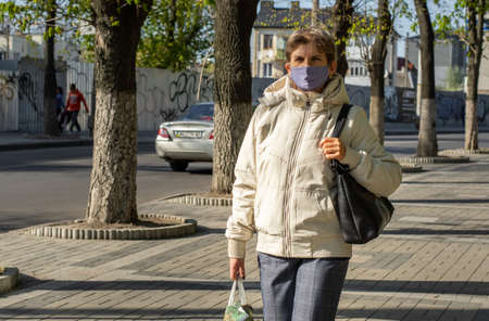 Lutsk, Ukraine - May 20,2020: A woman wearing face mask on a public streets in the middle of...