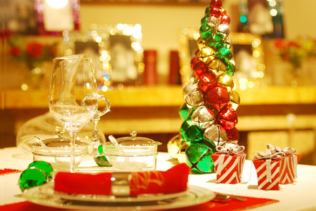 Christmas table setting in traditional red and green with plates, cutlery, wine glassesの写真素材