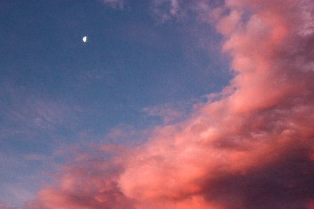 Beautiful sunset sky with clouds and the moon in the evening.の写真素材